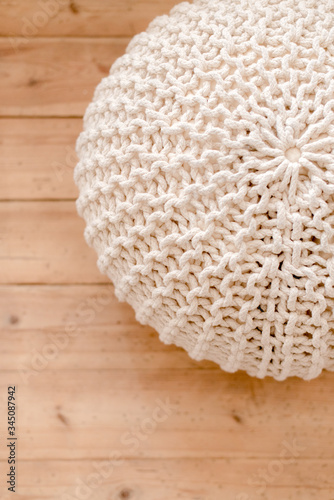 knitted pouf on wooden background photo