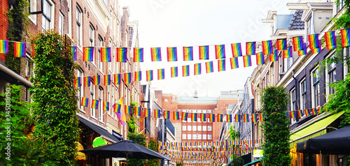 Amsterdam street with typical dutch houses, Holland, Netherlands. Used tinting. LGBT Rainbow Flag