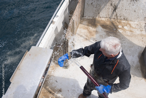 Man holding fishing equipment on a boat