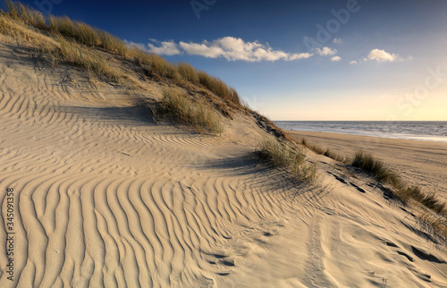 textured sand dune and blue sky by sea