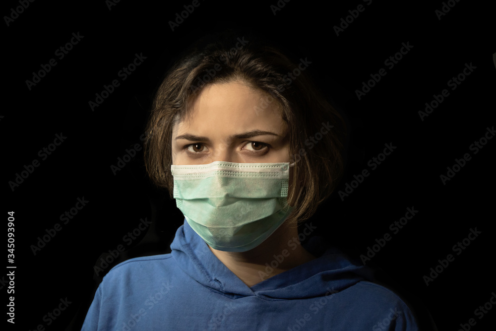 studio portrait of young woman wearing a face mask, isolated on black background studio portrait of young woman wearing a face mask, isolated on black background