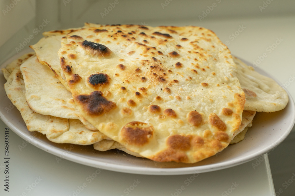 a plate of fried tortillas stands on a windowsill. a plate of fried tortillas stands on a windowsill.