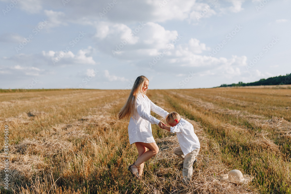 blond little boy playing with mom with white hair with hay in field. summer, sunny weather, farming. happy childhood. blond little boy playing with mom with white hair with hay in field. summer, sunny weather, farming. happy childhood.