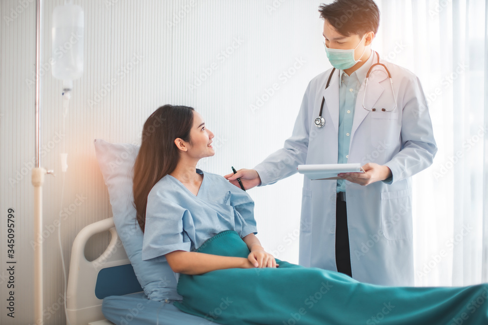 Obraz premium Medicine and health care concept. Asian doctor is taking care patient woman in hospital.doctor or nurse wear protection mask checking and takecare infection people from covid-19 .
