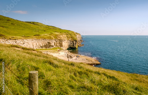 Looking East along the rocky Jurassic Coast from a cliff top coastal path with the Dancing Ledge, Langton Matravers, near Swanage, Dorset, UK on a warm Summer afternoon photo