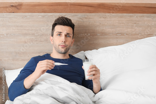 Young man ill with flu drin...