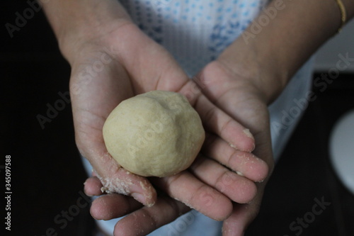 Fresh raw dough ball on hand.Indian chapati is a bread made of whole wheat flour.