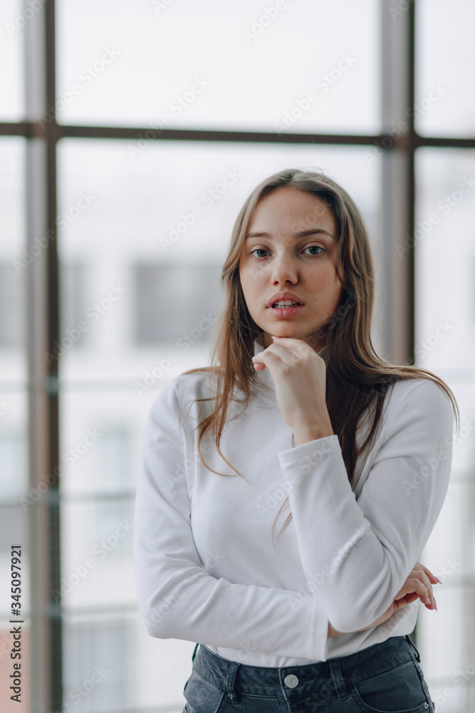 attractive girl on the background of the window shows different emotions and mood. girl on a light background indoors. attractive girl on the background of the window shows different emotions and mood. girl on a light background indoors.
