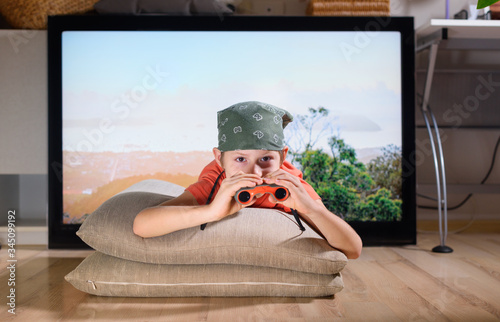 Boy lying down imitating scouting with field-glass
