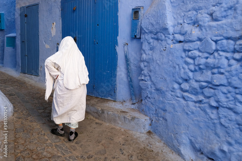 Local woman in white cloak in the city of  Chefchaouen,Morocco. © leospek
