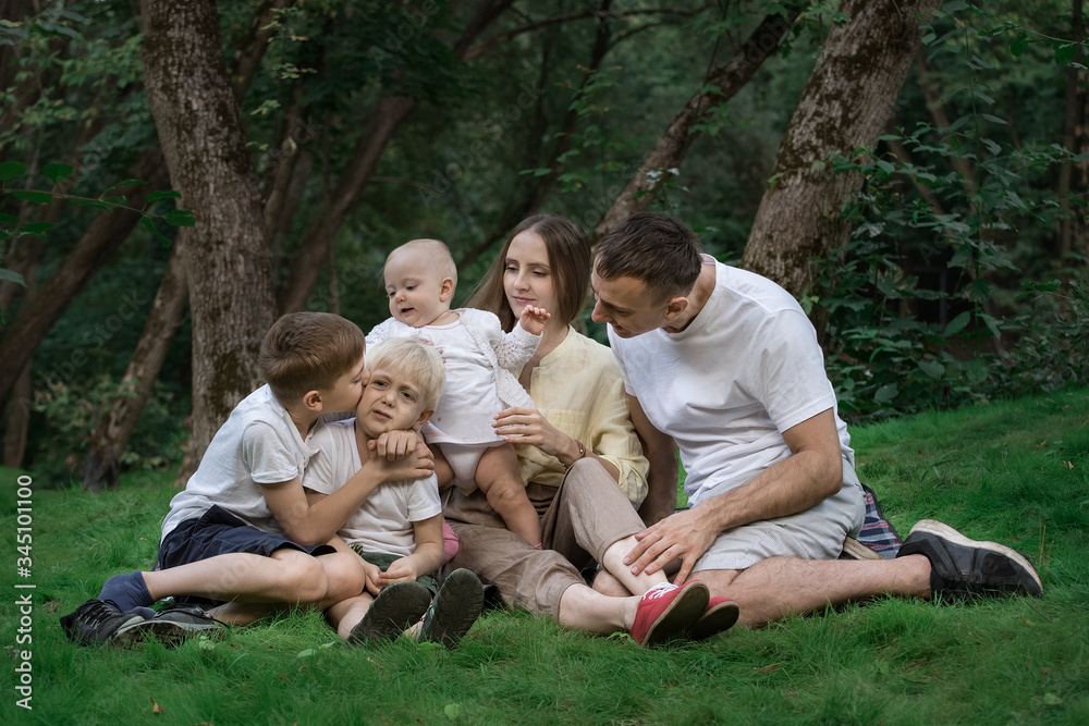 Family picnic outdoors. Mum dad and three children spend quality time together Family picnic outdoors. Mum dad and three children spend quality time together