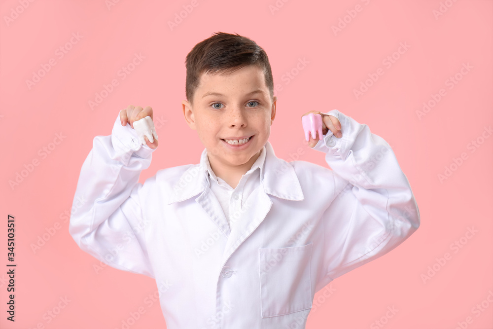 Little dentist with models of teeth on color background Little dentist with models of teeth on color background