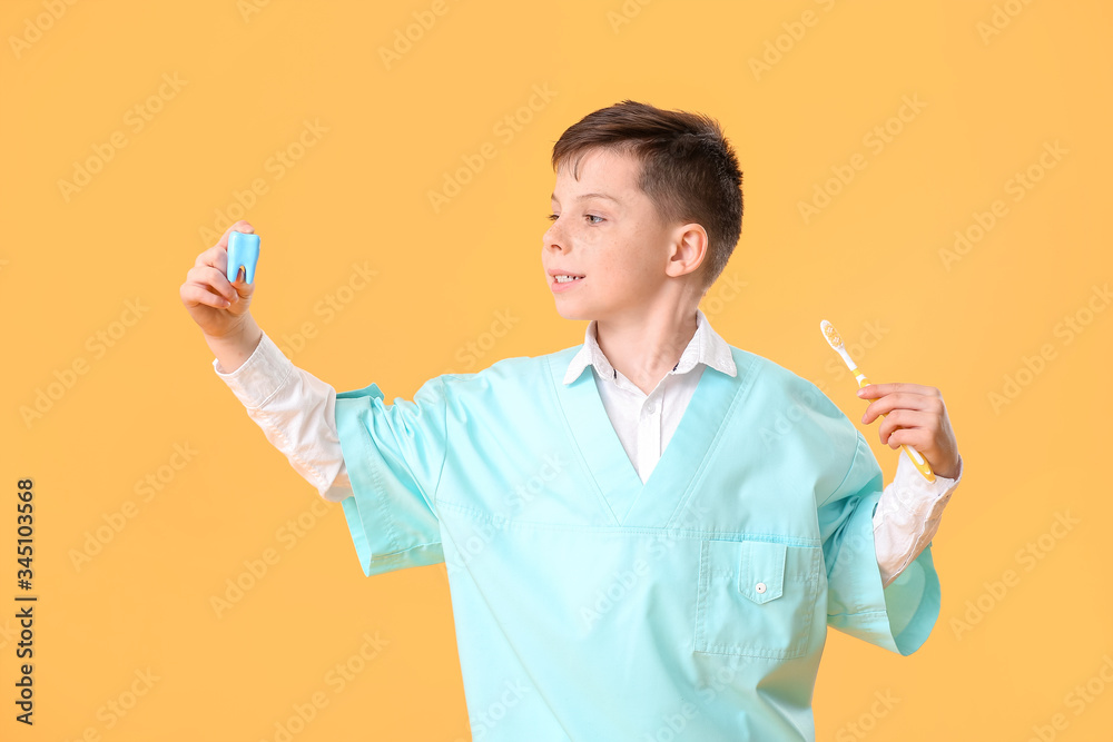Little dentist with model of tooth and brush on color background Little dentist with model of tooth and brush on color background