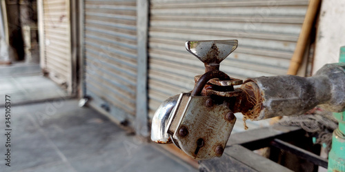A tap of water with a rusty lock in area of water shortage during lock down