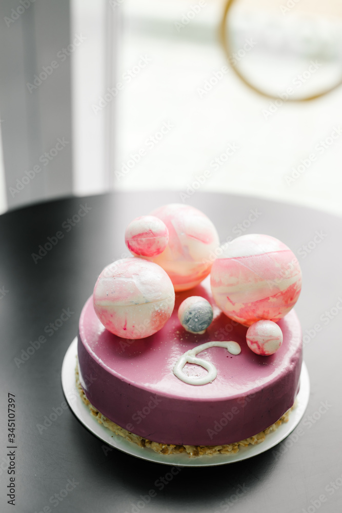 purple cake with chocolate balls of different sizes and the number six purple cake with chocolate balls of different sizes and the number six
