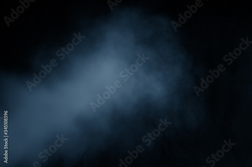 Blue clouds of smoke vapor isolated on a black background. The magic effect can be used when applying and changing