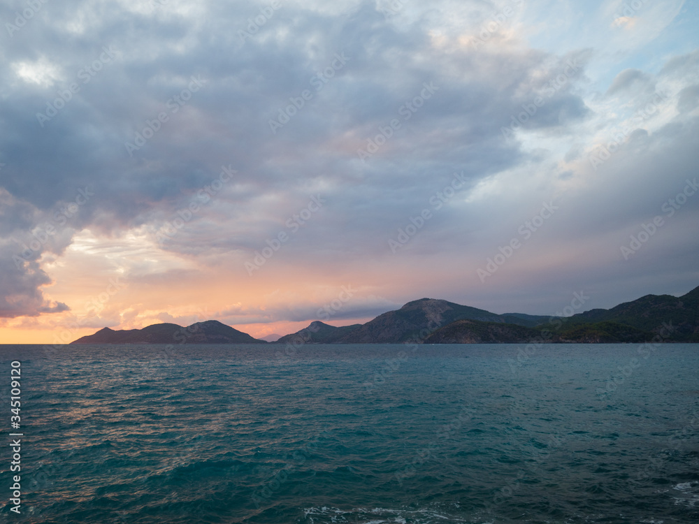 Epic sunset (dawn) on the sea. Waves are breaking on stones.