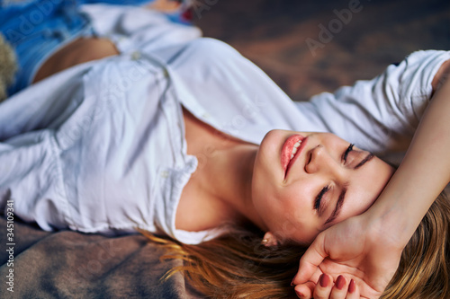 Lovely smiling woman is lying on the bed.