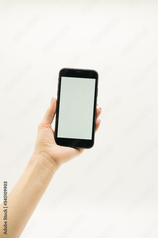 Woman's hand holds a black phone with white screen on white background. Woman's hand holds a black phone with white screen on white background.