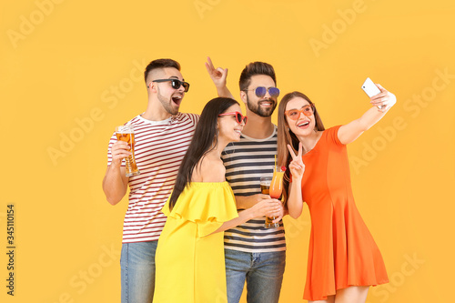Happy young people taking selfie on color background