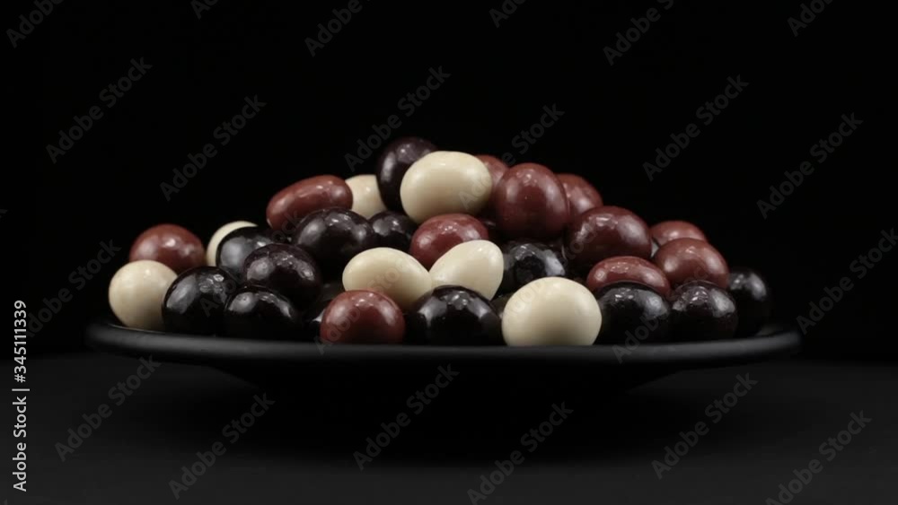 Dragee grains of spin around themselves on a black background and ground Dragee grains of spin around themselves on a black background and ground