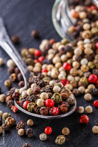 mix of peppercorns on a dark stone background