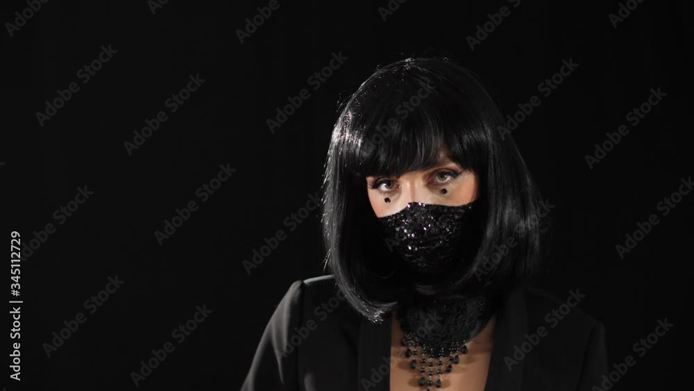 close-up of a girl on a black background with fashion makeup, from shiny rhinestones to a half-face, makes a U-turn looking at the camera close-up of a girl on a black background with fashion makeup, from shiny rhinestones to a half-face, makes a U-turn looking at the camera