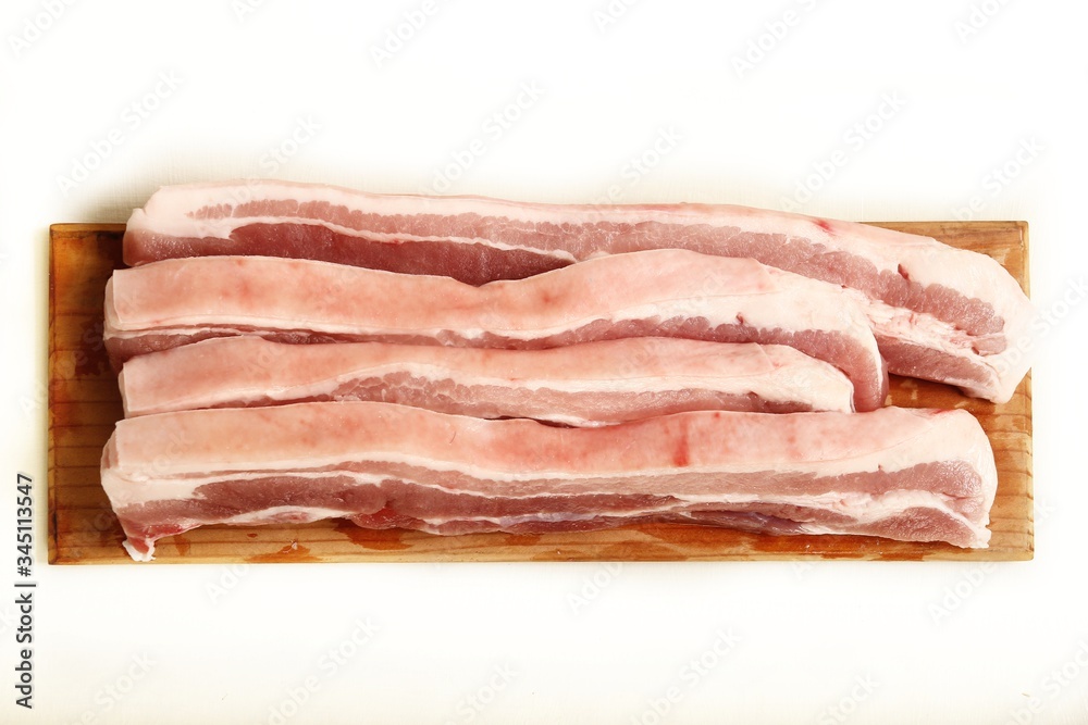 Fresh and raw sliced pork belly meat on an isolated white background Fresh and raw sliced pork belly meat on an isolated white background