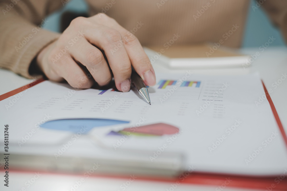 business woman working and calculating about finance with strategy graph chart, document report and notebook on desk at home, work from home, digital online marketing and financial business concept business woman working and calculating about finance with strategy graph chart, document report and notebook on desk at home, work from home, digital online marketing and financial business concept