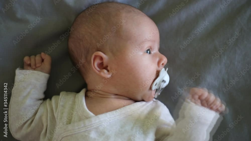 Close-up portrait of a beautiful month baby on grey blanket in home bed Close-up portrait of a beautiful month baby on grey blanket in home bed
