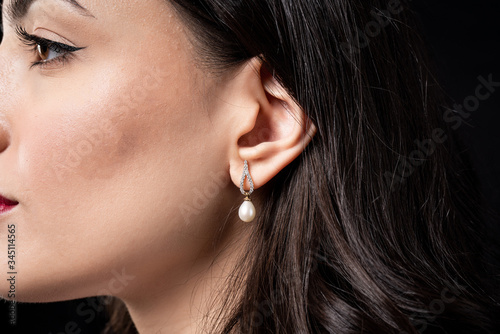 woman wearing pearl diamond earrings