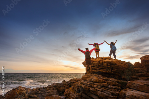 Hiking team, Teamwork concept, Successful team, Team with success standing on the top of mountain, The climbers raised both hands above their heads to signify victory.