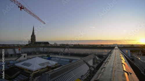 Une grue de chantier reprend le travail au lever du jour sur les toits de la vielle ville de Nantes  photo