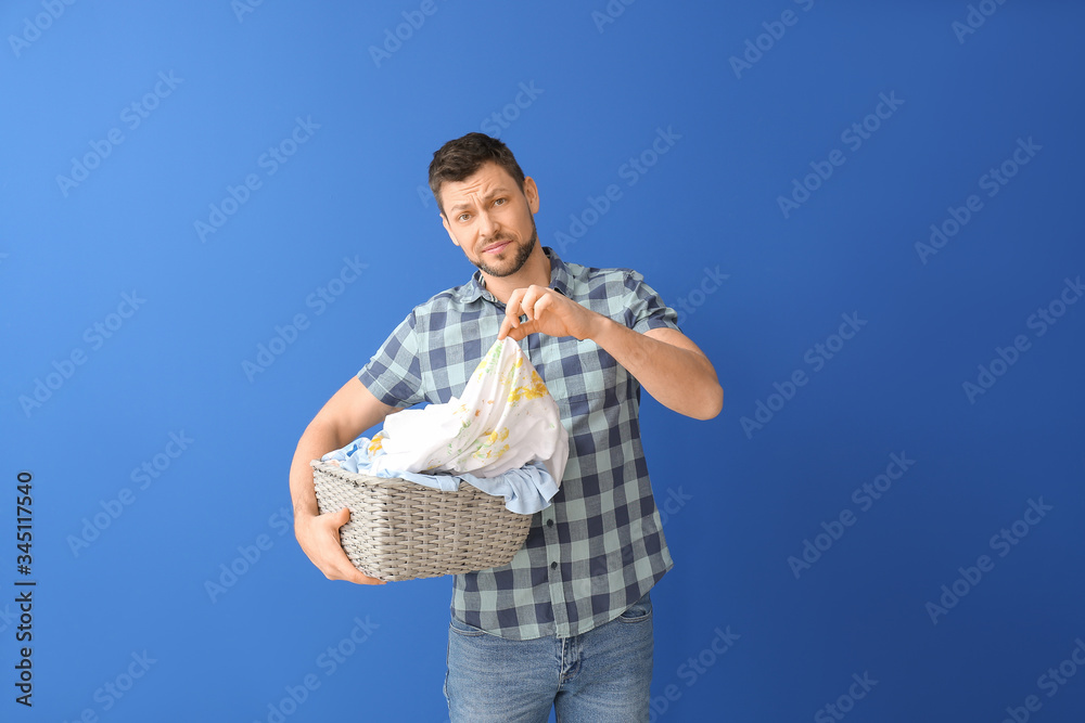 Displeased man with dirty clothes on color background Displeased man with dirty clothes on color background