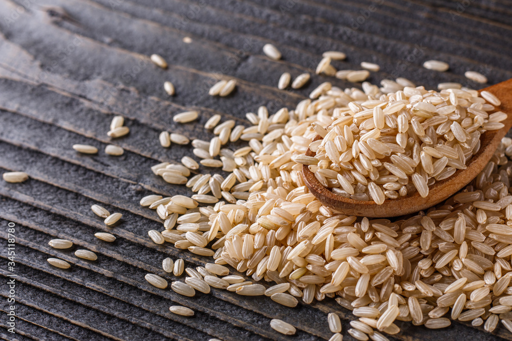 Obraz premium raw brown rice on dark rustic wooden background