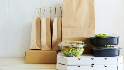 Different paper packages and containers for takeaway food on table. Takeout meal, deivery to home, food delivery, online shopping concept.