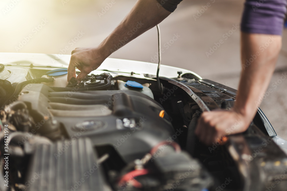 Man master repairs under the hood of the car Man master repairs under the hood of the car