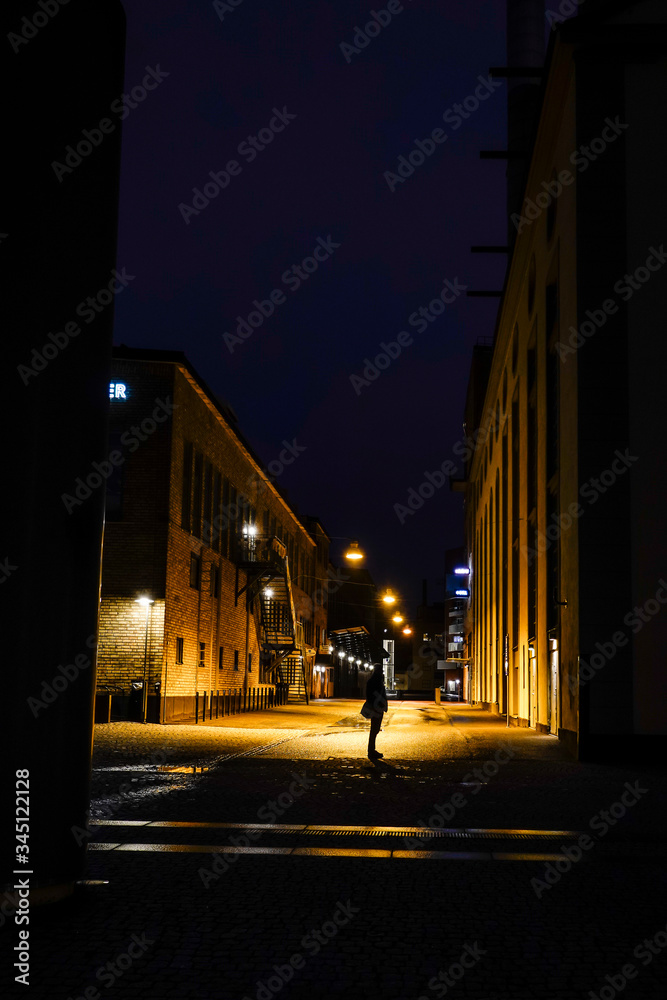 Norrkoping, Sweden A man stands at night in the old and renovated industrial mill section of town.