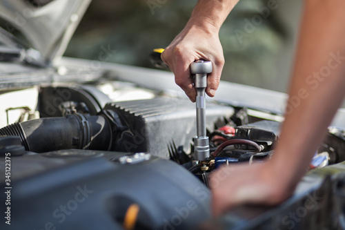 Man master repairs under the hood of the car