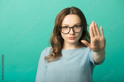 beautiful young woman in dress on green background with hand gesture