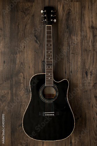 black acoustic guitar on wooden background