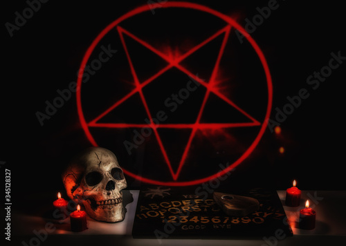 Murais de parede A satanic seance ritual scene with a skull, ouija board, planchette and red burning candles