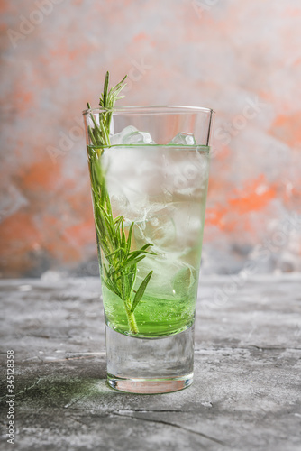 Sweet tequila based green cocktail with tarragon and rosemary. Selective focus. Shallow depth of field.