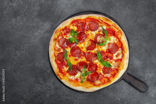 Pepperoni pizza with cherry tomatoes, cheese on black background