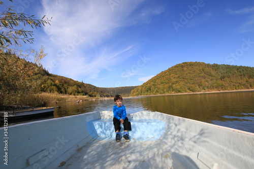 Child boating on the lake, on a beautiful autumn day