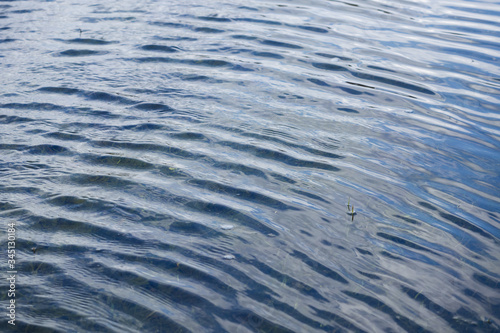Ripples and reflection of clouds on the surface of the water. Background. Texture.