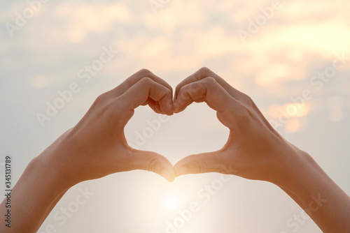 Female hands in the form of heart against sunlight in sunset sky, Love concept, Hands in shape of love heart, love Concept, Heart-shape hand gesture