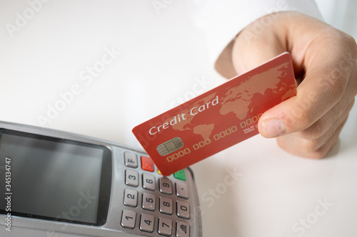 Hand of customer paying with contactless credit card with NFC technology.