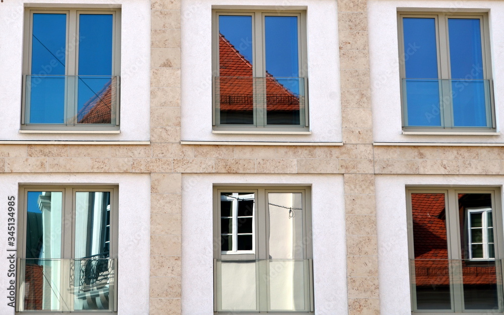 Obraz premium Altbau in Freiburg spiegelt sich in einer Neubaufassade