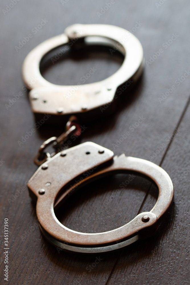 steel metal Handcuffs on brown background steel metal Handcuffs on brown background